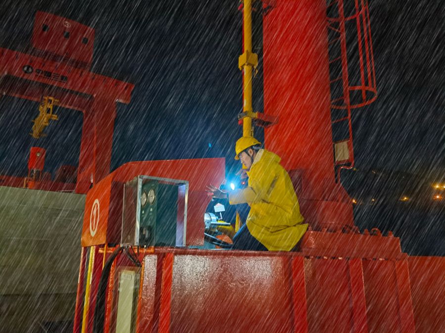 向家坝电厂员工寒潮期冒雨进行户外设备检查-时露林